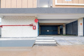 A building entrance with a fire hose, a fire alarm, and a closed garage door.