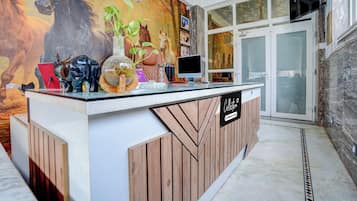 Una recepción con un mural con tema de caballos, un televisor y un letrero que dice 'Collection 5'.