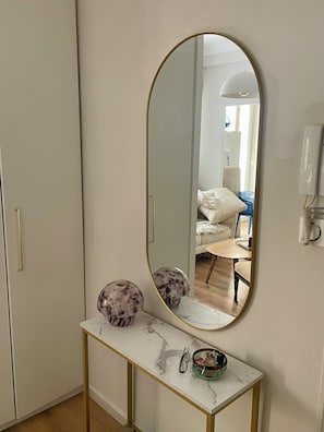 A room with a white wardrobe, a marble console table, and a large oval mirror. - New Listing (Nice)