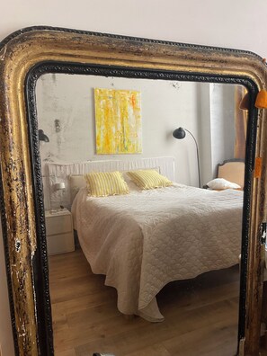 Ein Schlafzimmer mit einem Bett, Nachttischen, einer Lampe und einem Bild an der Wand.
