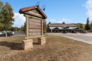 A wooden signboard with business names and a phone number for Silverthorne Inn. - Spacious 5BR Wildernest Home | Private Hot Tub & Views (Silverthorne)