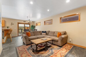 A living room with a sectional sofa, a coffee table, and a patterned rug. - Spacious 5BR Wildernest Home | Private Hot Tub & Views (Silverthorne)