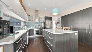 A modern kitchen with a central island, built-in appliances, and a pendant light. - Your Perfect Inverloch Getaway (Inverloch)