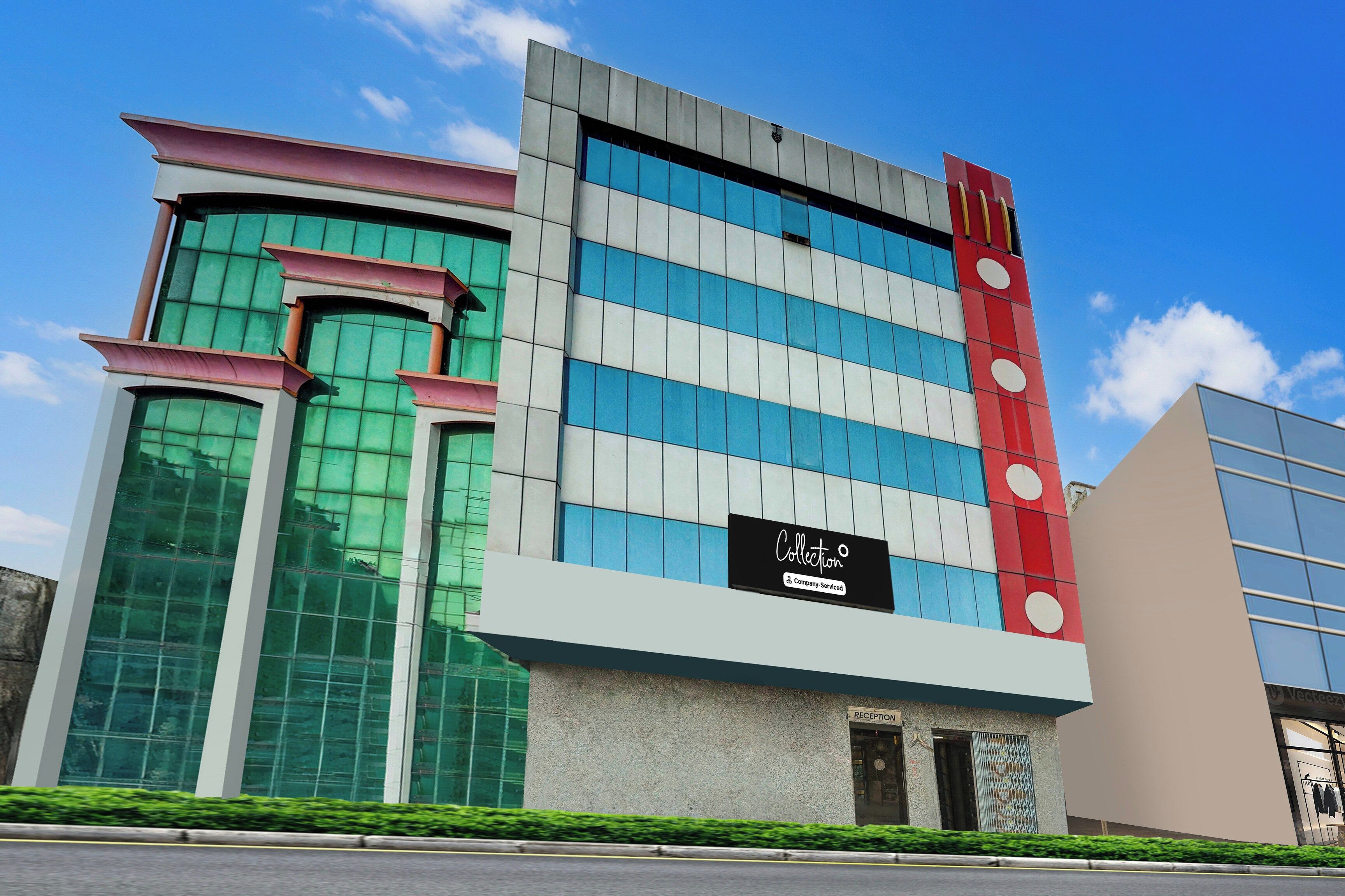 Un edificio moderno con fachada de vidrio, una zona de recepción y un cartel que indica que es un lugar de servicios para empresas.