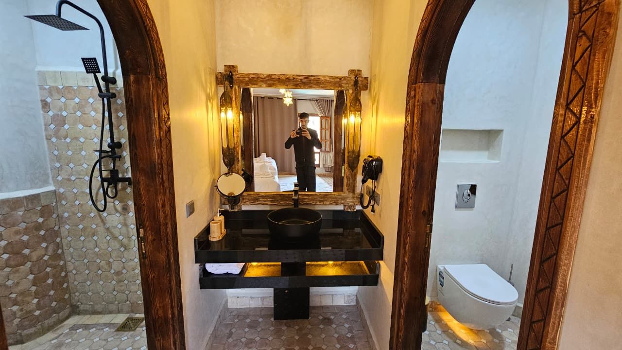 A bathroom with a shower, a sink with a mirror, and a toilet.