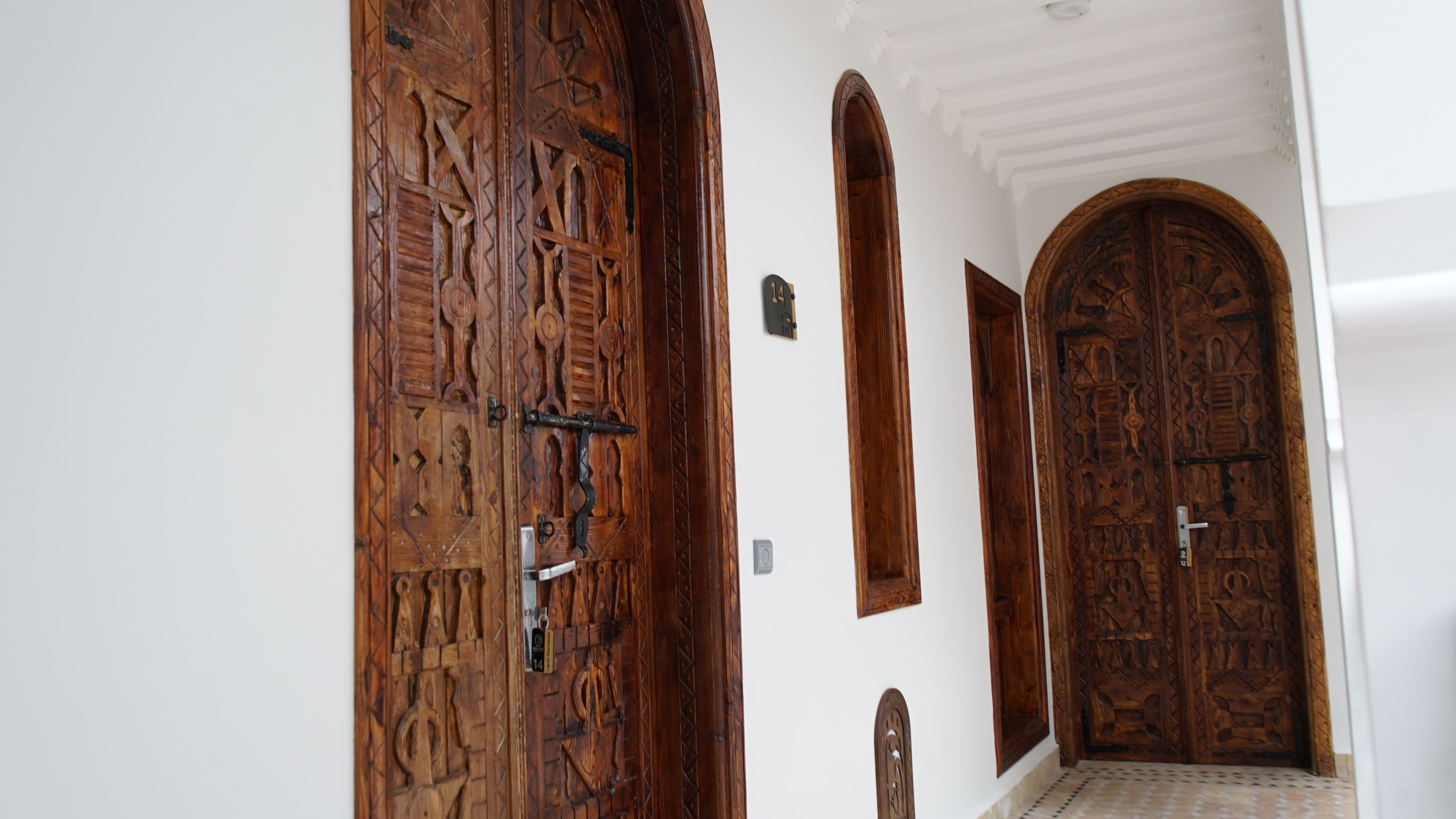 A hallway with three wooden doors, each with intricate carvings.