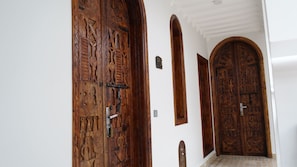 A hallway with three wooden doors, each with intricate carvings.