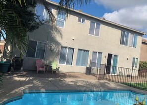 Ein zweistöckiges Gebäude mit einem Pool im Vordergrund.