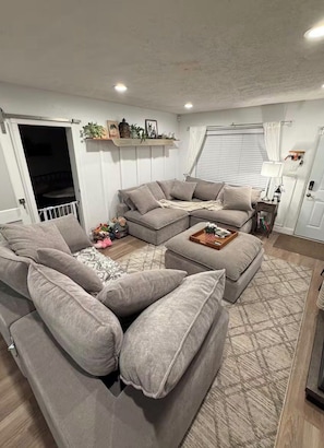 Una sala de estar con sofá modular, reposapiés y una mesita con bandeja.