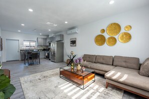 A modern living room with a sofa, coffee table, and decorative wall art.