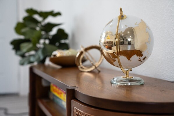 Un globe terrestre posé sur une surface en bois, avec une plante en arrière-plan.