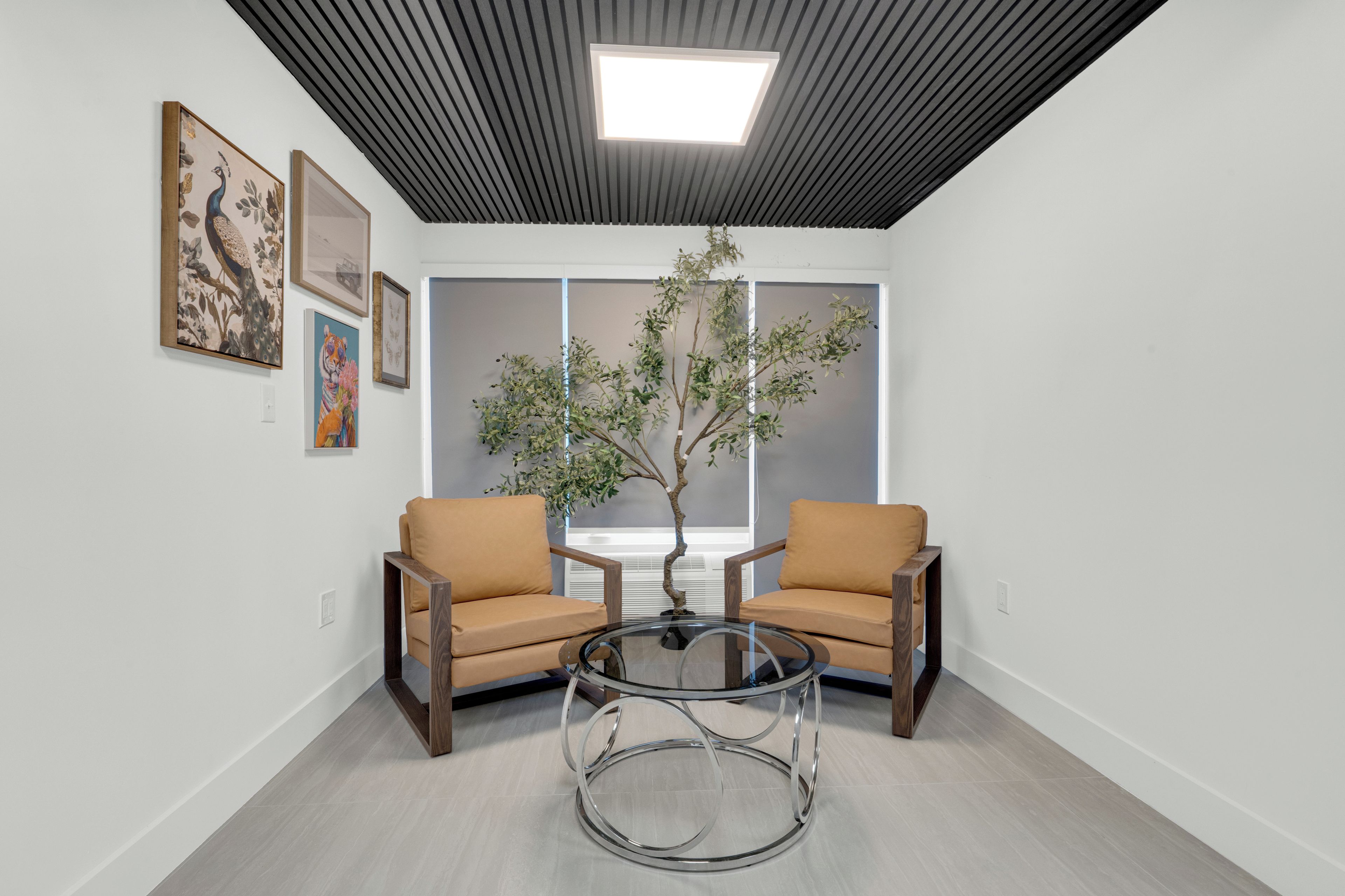 A room with two chairs, a glass table, and a ceiling light.