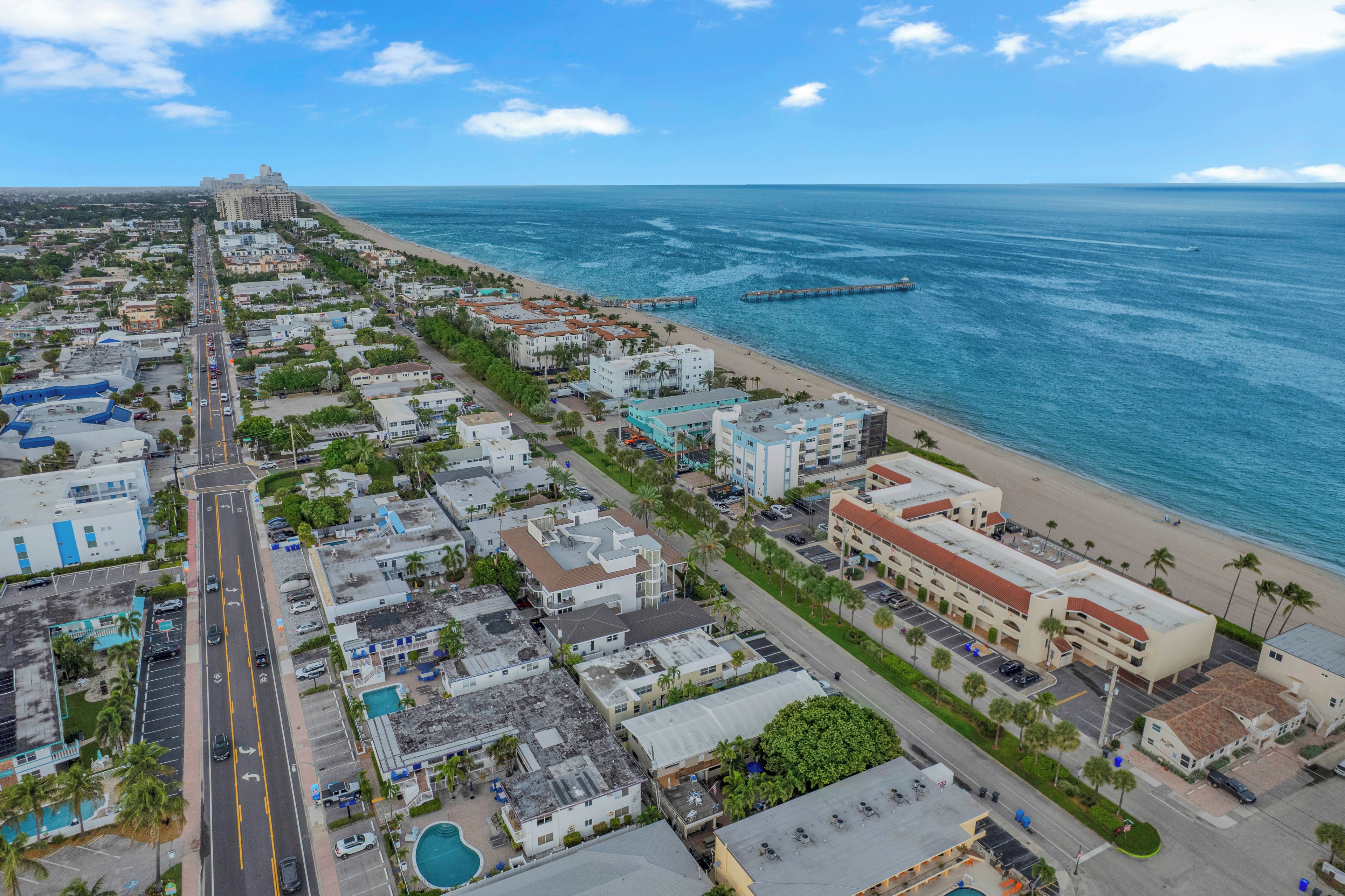 Vista aérea de una ciudad costera con playa, calles y edificios.