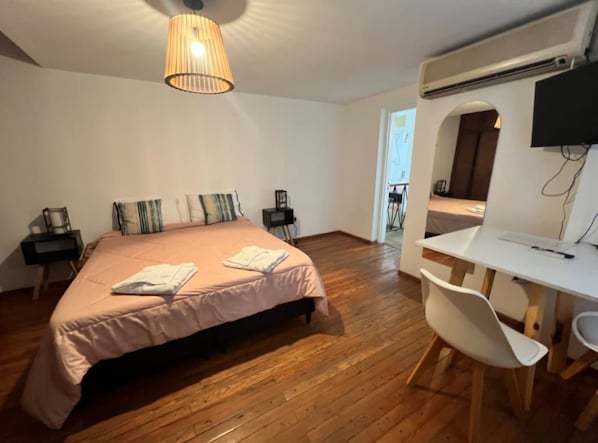 A bedroom with a bed, bedside tables, a desk, and a chair. - Casa Oliva B&B (Mendoza)