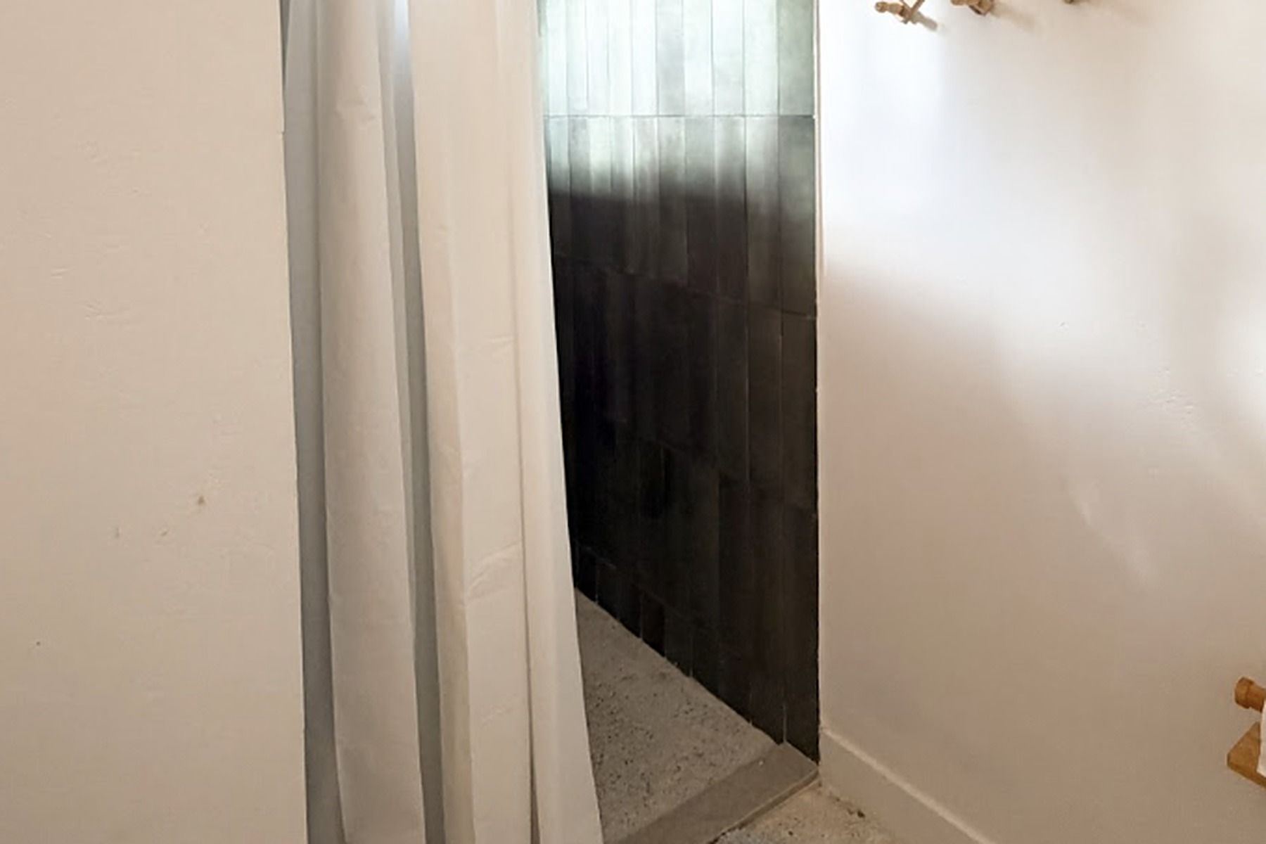 A narrow hallway with a door leading to a dark room.