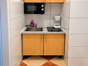 A compact kitchen with a microwave, coffee maker, and a sink. - Your Vienna Routine 1BR and Living Room (Vienna)