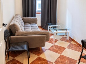 A compact living space with a sofa, a small table, and a chair. - Your Vienna Routine 1BR and Living Room (Vienna)
