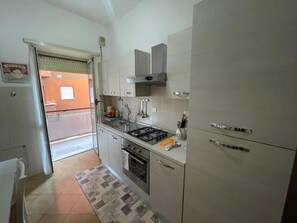 A kitchen with a gas stove, oven, and a stainless steel range hood. - Yes Rome Holidays - One Bedroom Apartment, Sleeps 5 (Rome)