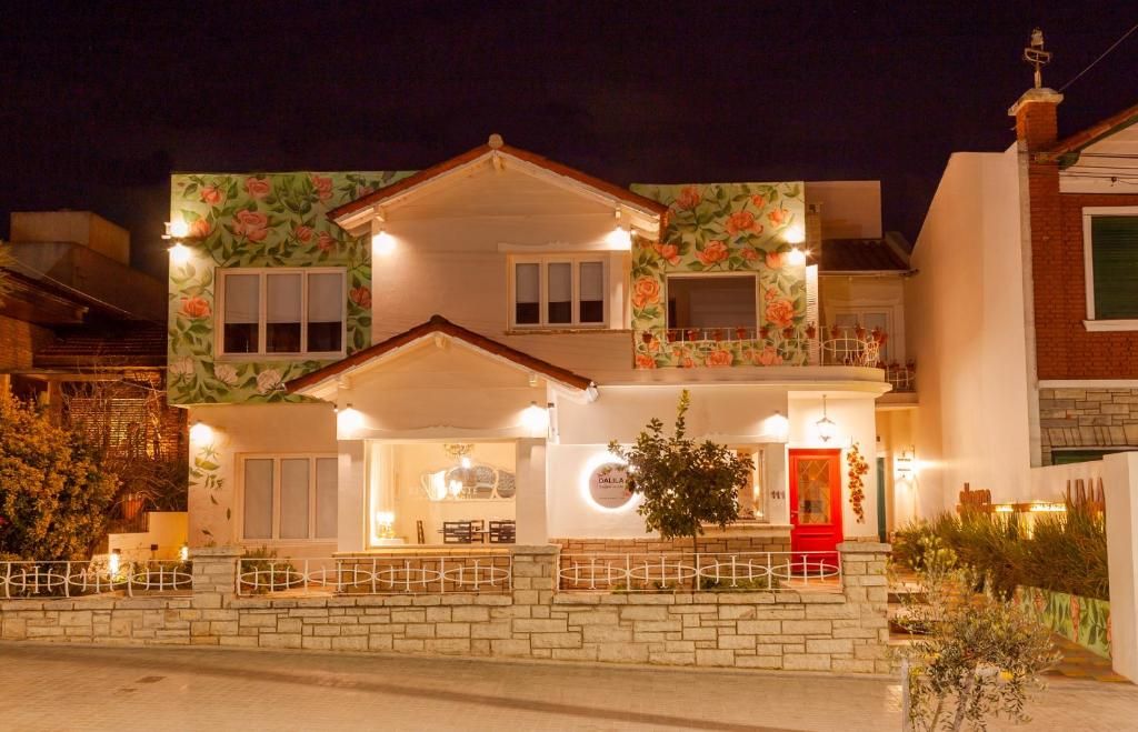 A two-story building with a red door, multiple windows, and a balcony.
