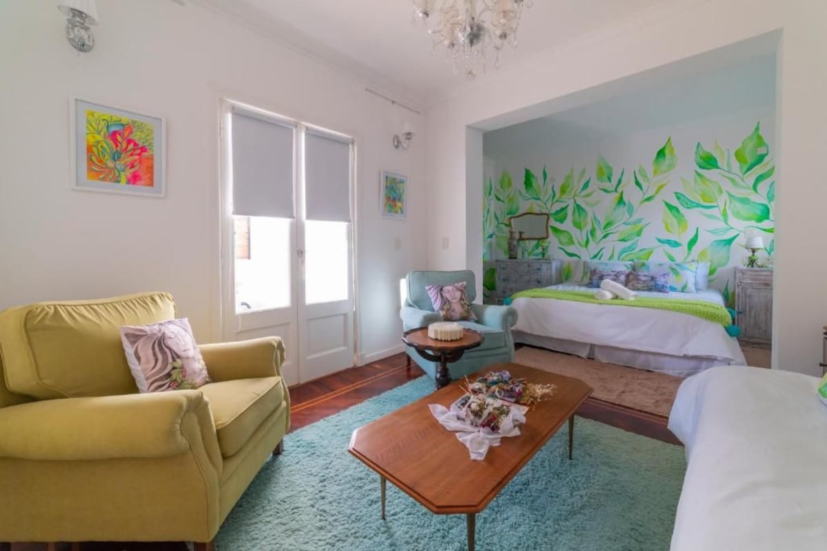 Een kamer met een bed, een slaapbank, een salontafel en een stoel.