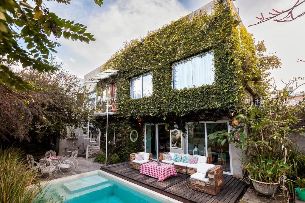 A house with a swimming pool, outdoor seating, and a garden.