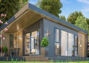 A modern building with large windows, a covered patio area, and a small outdoor seating space. - Autograph S pod Escape 4 (Hot tub) (Thirsk)