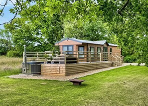 A wooden cabin with a deck, a hot tub, and a grill area. - 1 bedroom accommodation in Colyton (Colyton)