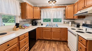A kitchen with wooden cabinets, a dishwasher, a stove, and a sink. - Lick Creek Pit Stop   
Dog friendly  
Direct trail access 
2 Kings 2 Queens (Williamson)