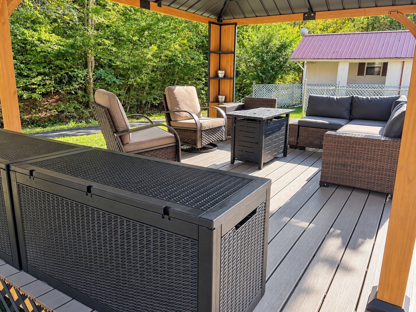 An outdoor patio with wicker furniture, a grill, and a covered area.
