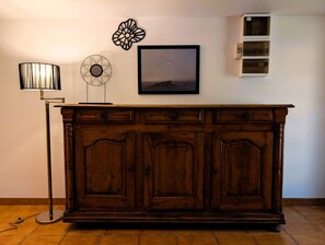 A wooden cabinet with three doors, a wall-mounted shelf, and a floor lamp. - Authentic Lake Geneva farmhouse near Évian (Larringes)