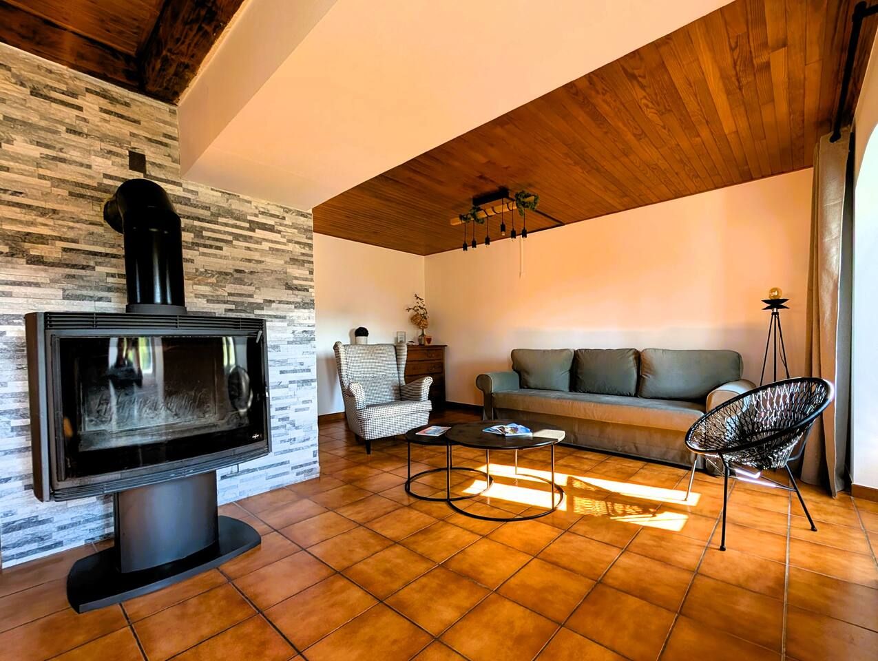 Ein Wohnzimmer mit Kamin, einer Couch, einem Sessel und einem Couchtisch.