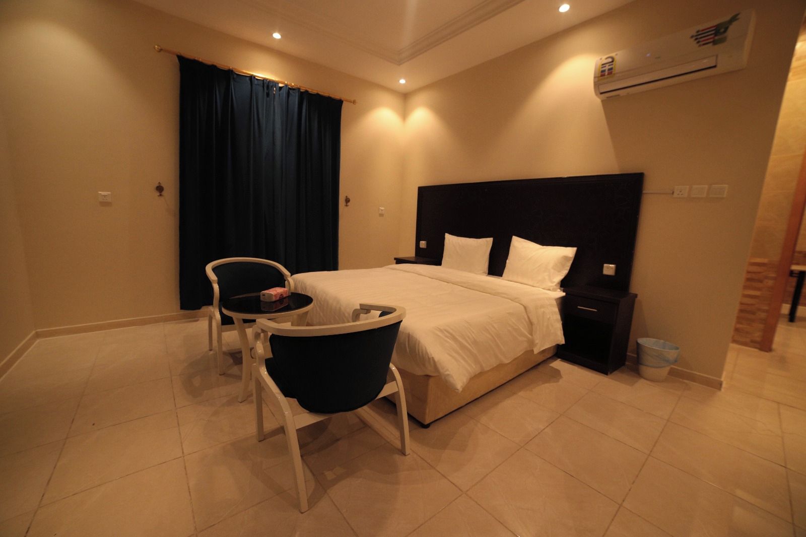 Ein Hotelzimmer mit Bett, Schreibtisch, Stuhl und Nachttisch.