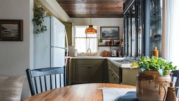 Une cuisine avec un plafond en bois, une table à manger avec des chaises et une grande fenêtre donnant sur un beau paysage.