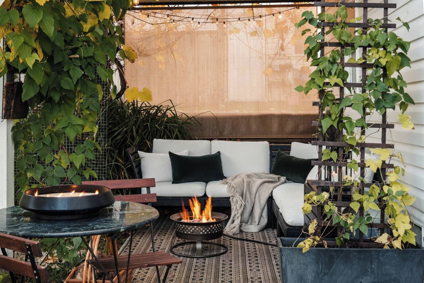 A cozy outdoor seating area with a fire pit, a sofa, and a table.