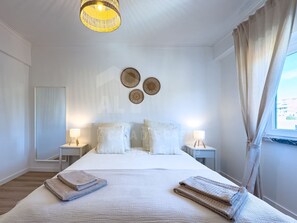A hotel room with a large bed, two bedside tables, a hanging light fixture, and a view of the outside. - Barbosa s House by Acasadascasas (Mafra)