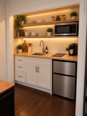 A modern kitchen with white cabinetry, stainless steel appliances, and a wooden countertop. - Cozy & Stylish 1-Bedroom Retreat Modern Comfort & Private Kitchenette (Tampa)