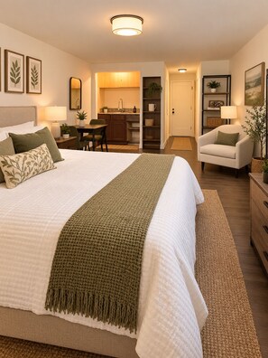 A hotel room with a large bed, a desk, a chair, a kitchenette, and a bathroom. - Cozy & Stylish 1-Bedroom Retreat Modern Comfort & Private Kitchenette (Tampa)