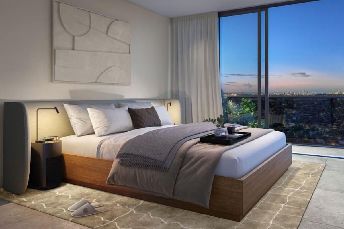 Une chambre moderne avec un grand lit, des tables de chevet et une vue sur la ville.