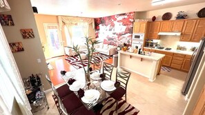 Une cuisine moderne avec des meubles en bois, un îlot central et un coin repas agrémenté d’un tapis à motifs zébrés.