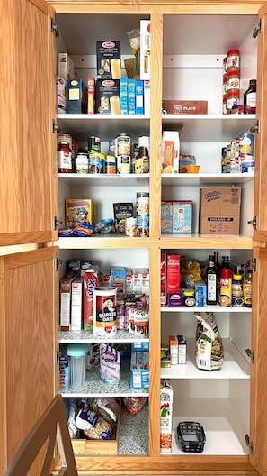 Eine Speisekammer mit verschiedenen Lebensmitteln und Küchenutensilien.