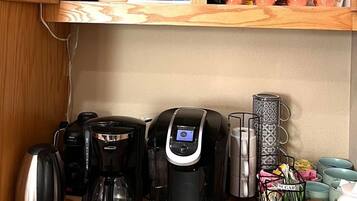A kitchen with wooden cabinets, a coffee station, and various tea and coffee products.