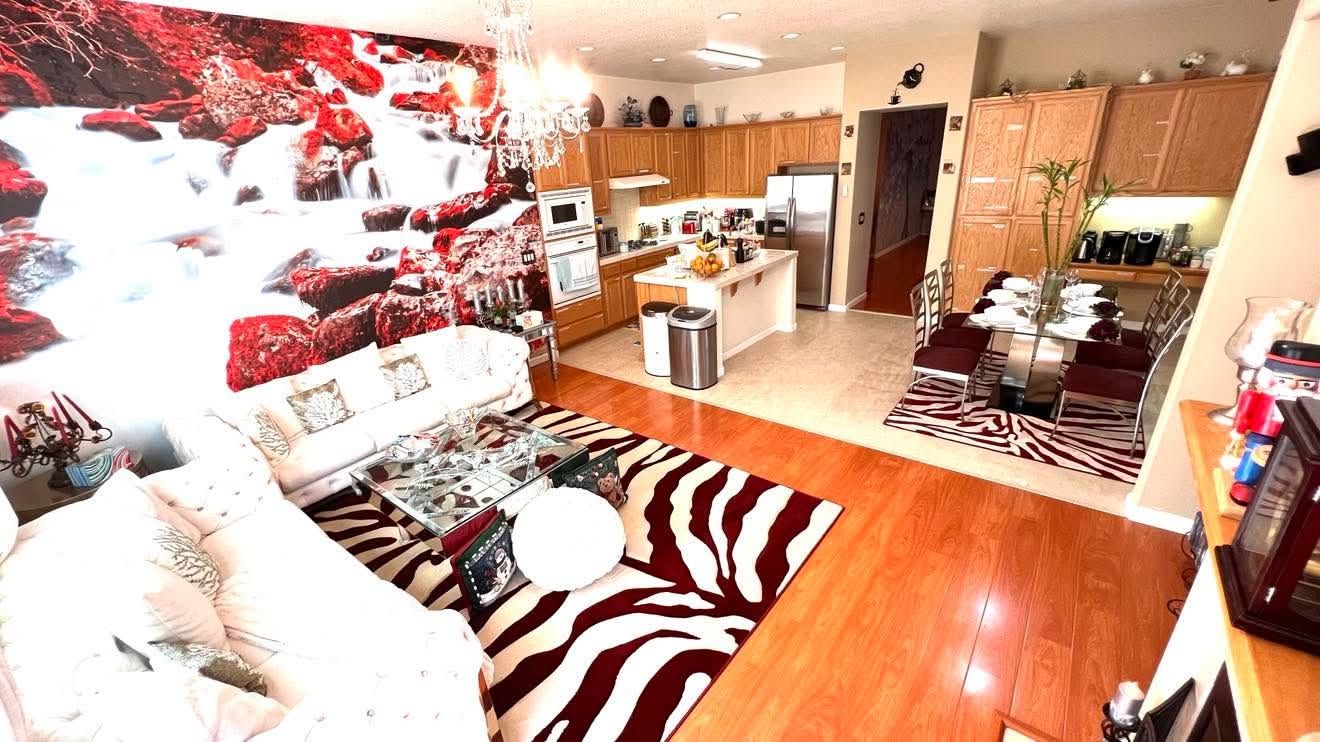 Una cocina moderna con armarios de madera, una isla central y un comedor con alfombra de estampado de cebra.