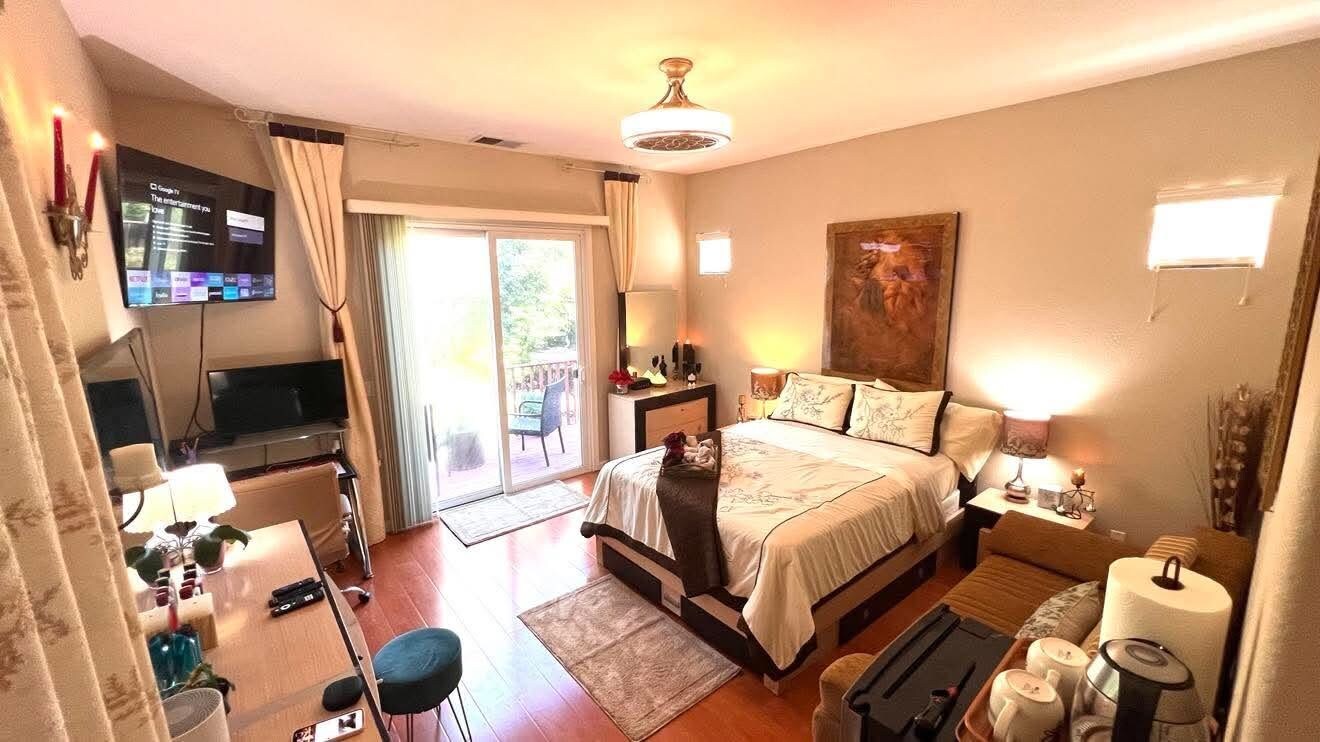 Une chambre d’hôtel équipée d’un lit, d’une table de chevet, d’une lampe et d’un téléviseur fixé au mur.
