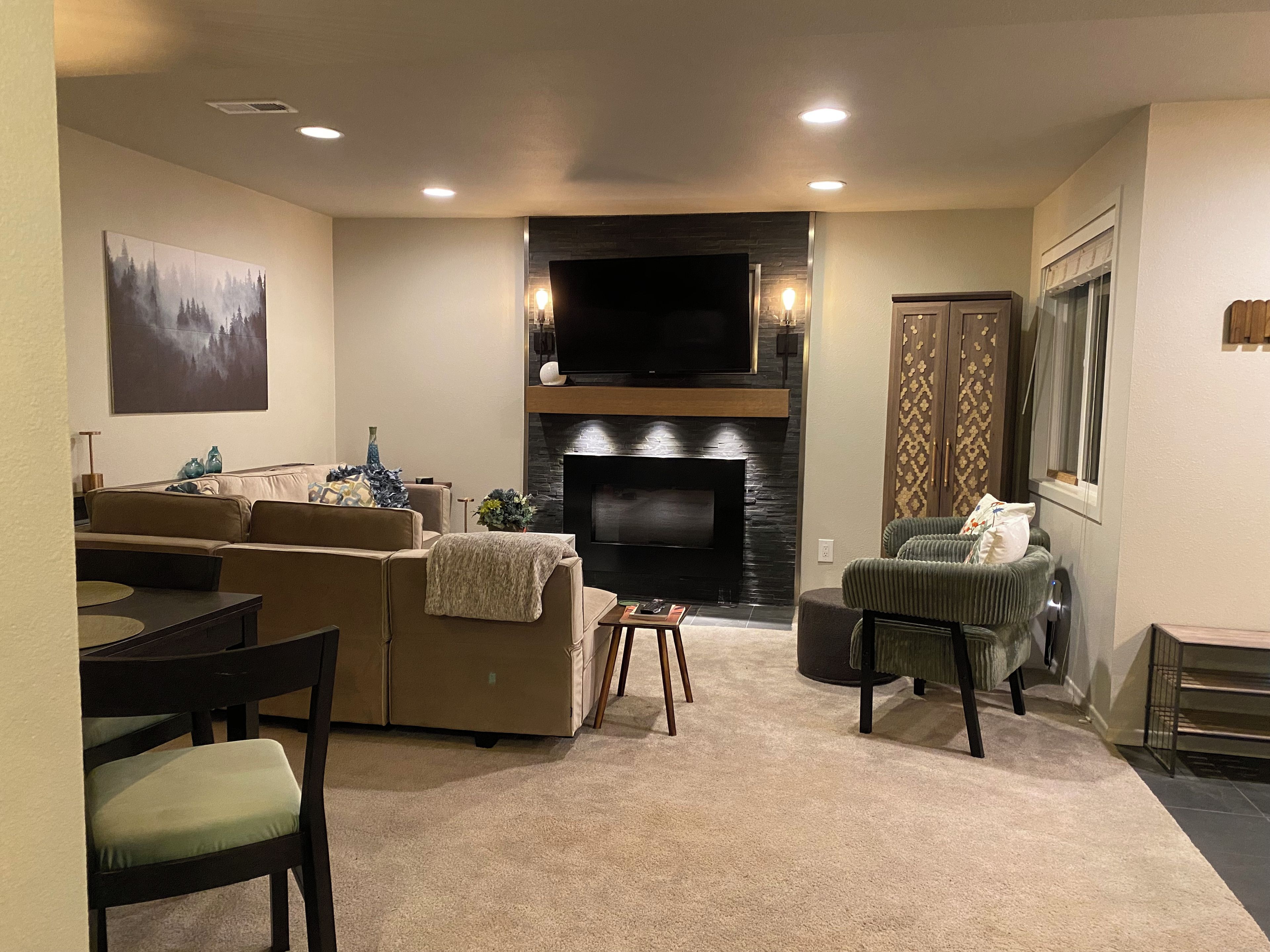 A living room with a fireplace, sofa, and television.