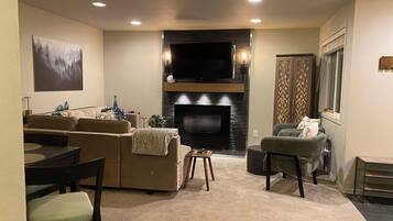 A living room with a fireplace, sofa, and television.
