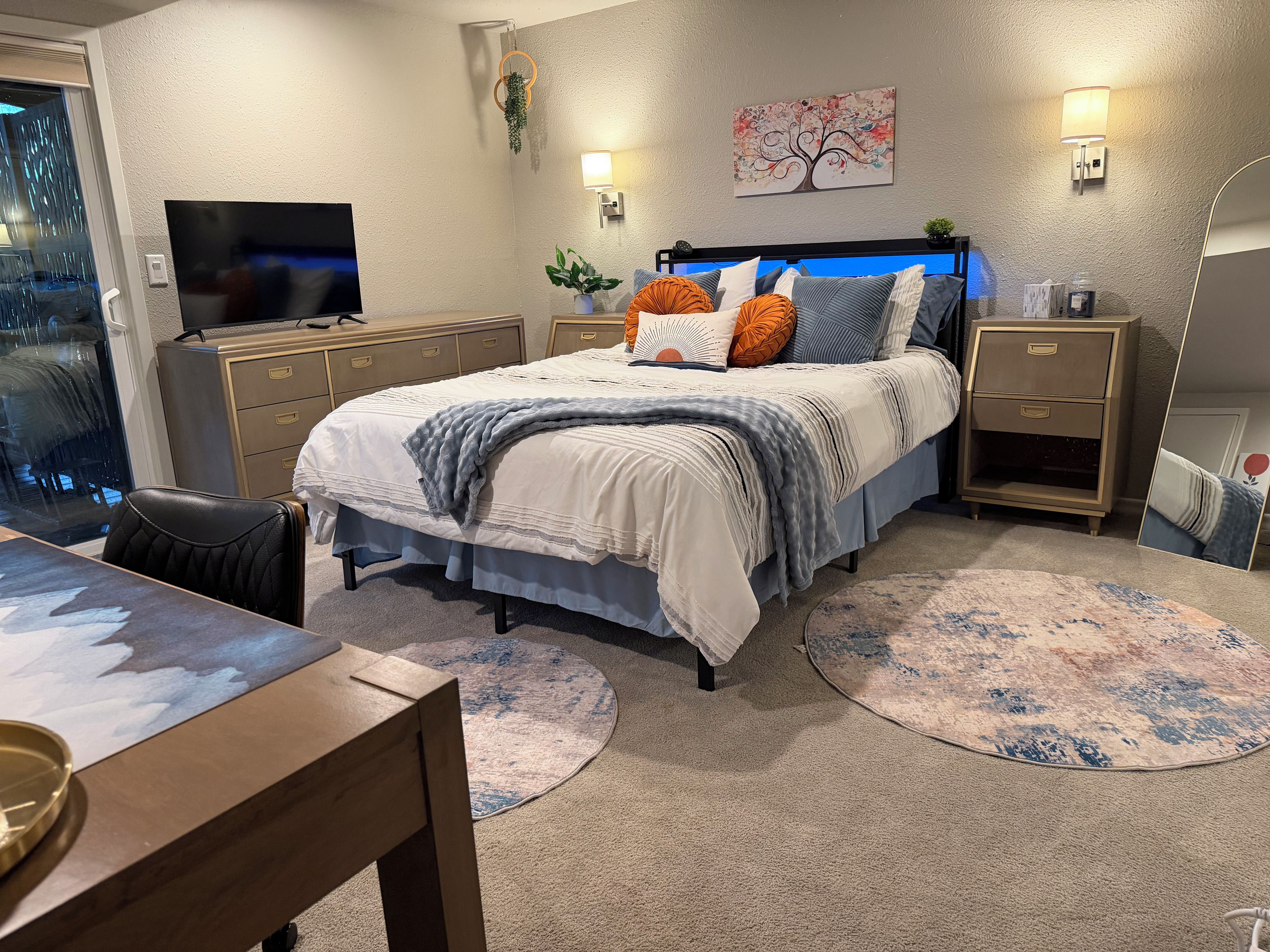 Ein Schlafzimmer mit Bett, Nachttischen, Fernseher und Fenster.
