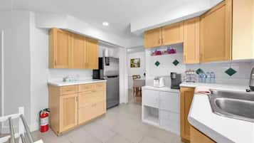 Una cocina moderna con armarios de madera, un lavamanos de acero inoxidable y un refrigerador.