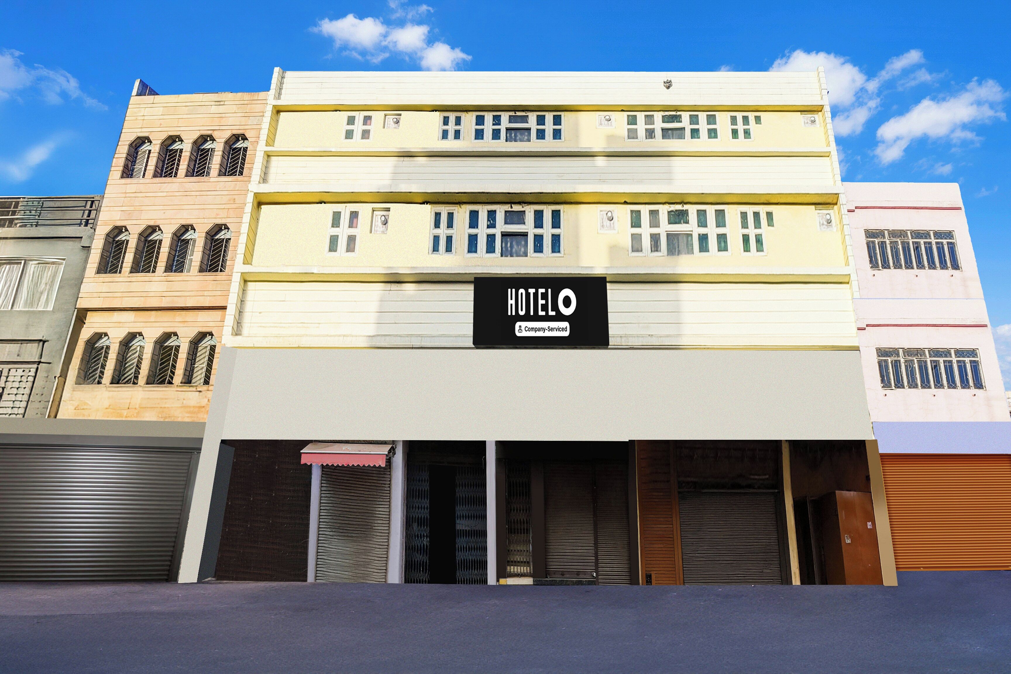 A multi-story hotel with a prominent 'HOTEL' sign on the facade, featuring a company-serviced logo.