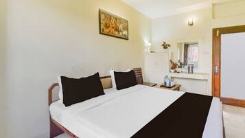 A hotel room with a bed, a nightstand, a mirror, a wardrobe, and a painting on the wall.