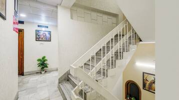 A staircase with white railings leading to a landing.